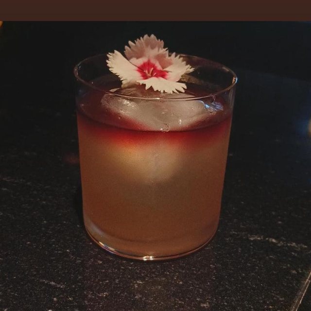 Cóctel con flor comestible sobre hielo